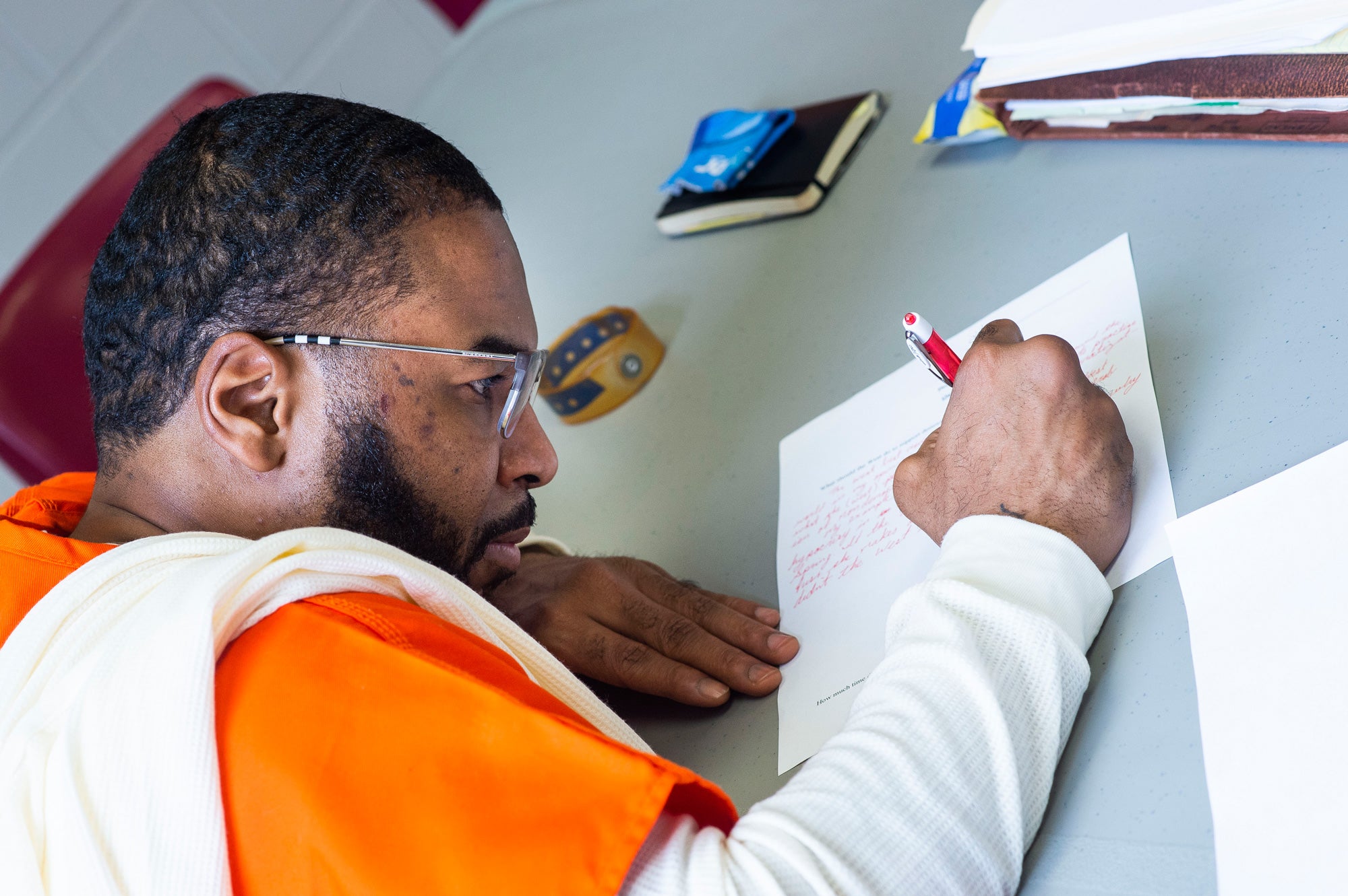 An incarcerated man works on an assignment