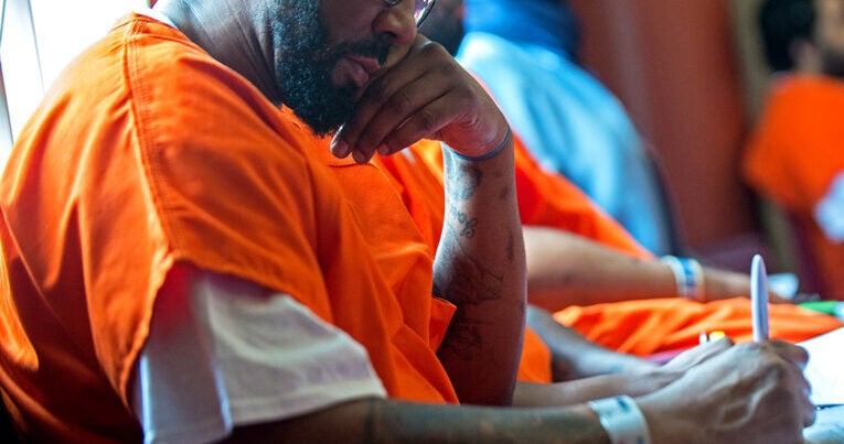 A Georgetown Prison Scholar writes in a notebook.