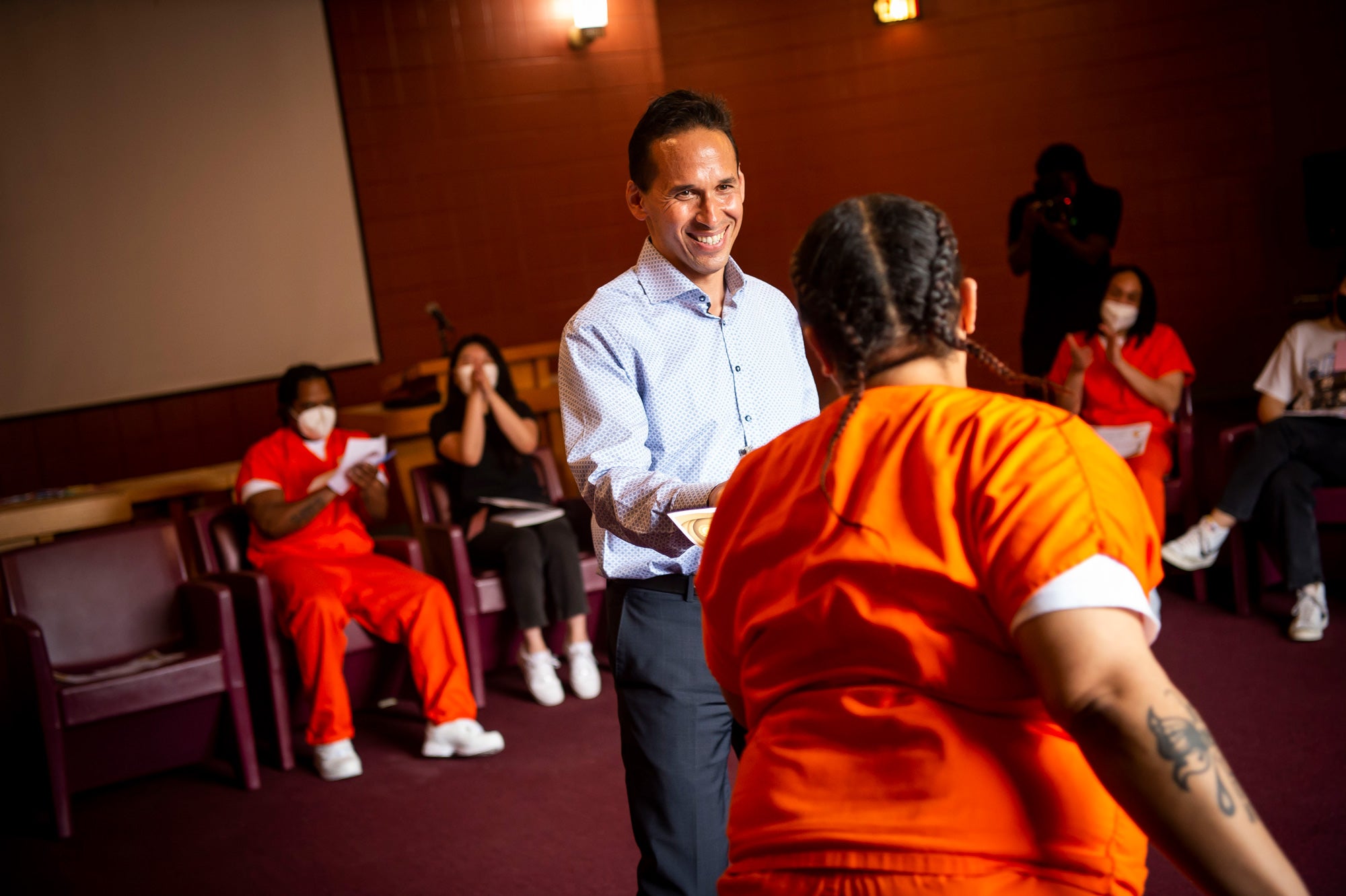 Marc Howard hands a certificate to an incarcerated Scholar