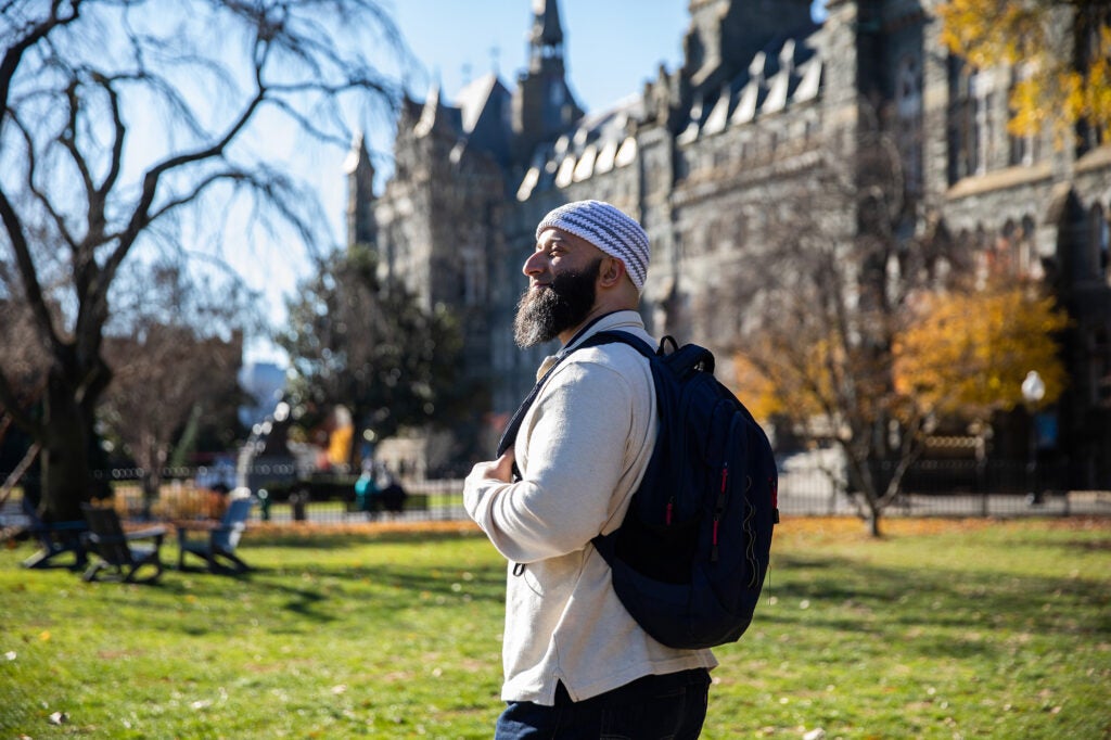 Adnan Syed walks along Healy Lawn on Georgetown University's Main Campus.