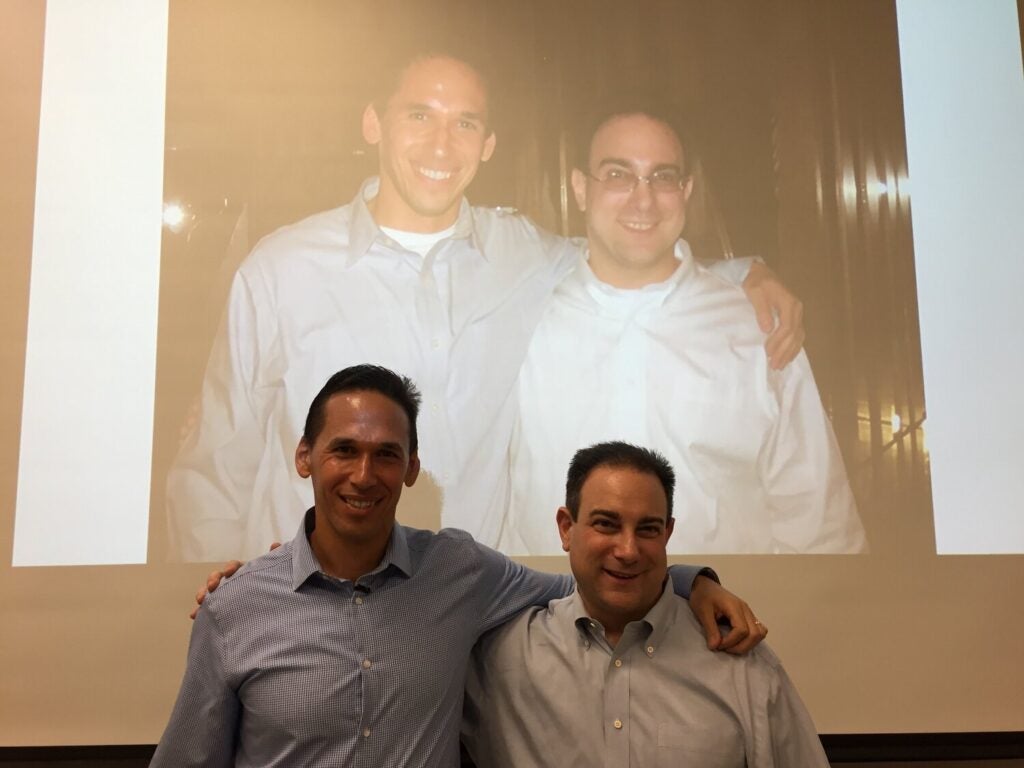 Marc Howard and Marty Tankleff pose in front of a photo of them in 2007.
