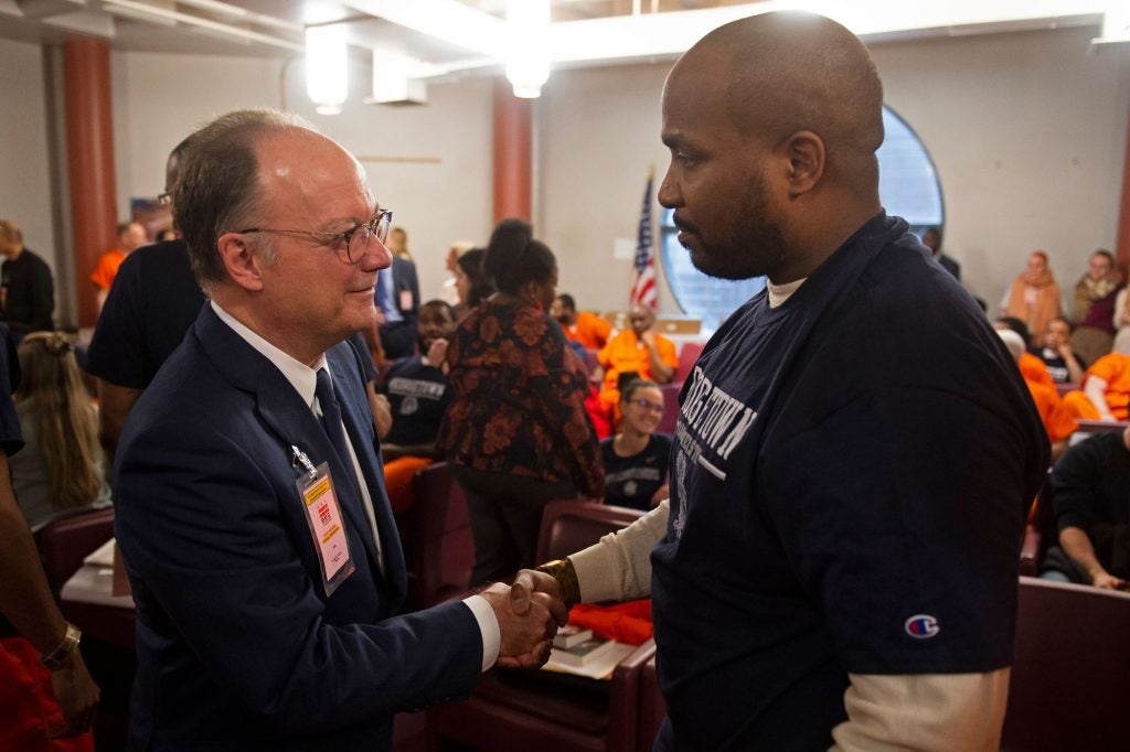 Georgetown President John DeGioia shakes hands with Prison Scholar Warren Allen.
