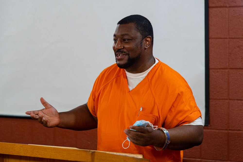 Georgetown Prison Scholar Xavier Lee speaks from a podium.