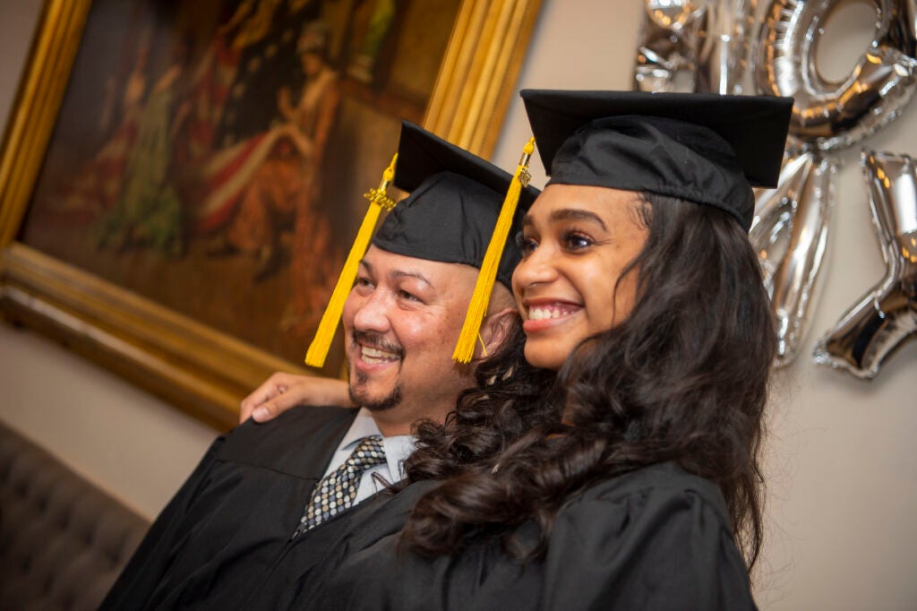 Brianna Stutson and David Rider, in graduation caps and gowns, pose for a photo.