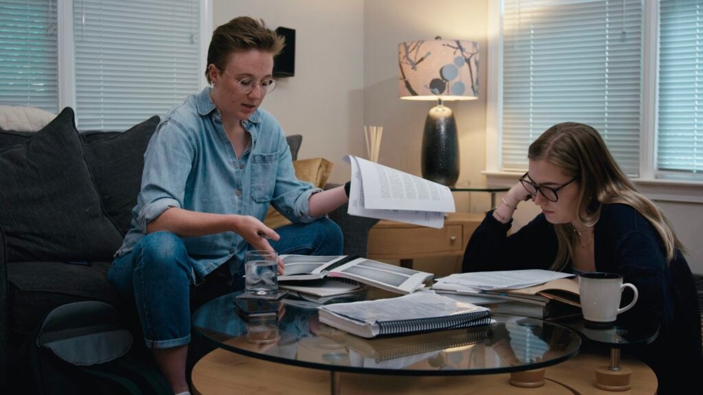 Grace Perret and Lizzie Porterfield flip through documents.